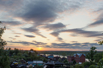 Cumulus clouds of fantastic shape soar in the sky in the sun's rays over the visible horizon line.