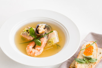 Restaurant cooking. Seafood soup plate and cheese caviar sandwich on white background.