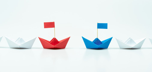Competition of two leaders concept with Blue and red paper ship leading among white on white...
