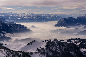 Fototapeta na wymiar Blick vom Geigelstein auf Nebel und schneebedeckte Bergkette