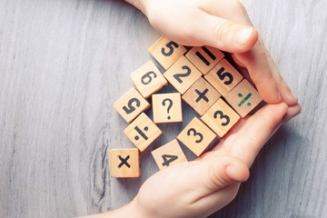 Wooden cubes with numbers. Teaching a child of preschool age mathematics. question mark. child learns numbers