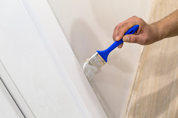 Decorator's hand painting wall with paint brush