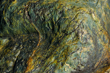 The surface of an old rock with cracks. Old rock texture (wild background)