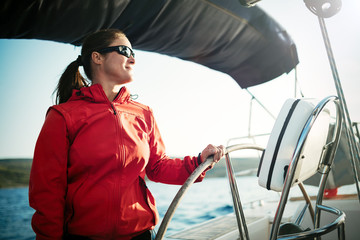 Attractive strong woman sailing with her boat