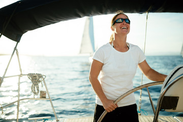 Attractive strong woman sailing with her boat