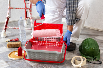 Professional house painter at work prepares the wall paint © francescomou