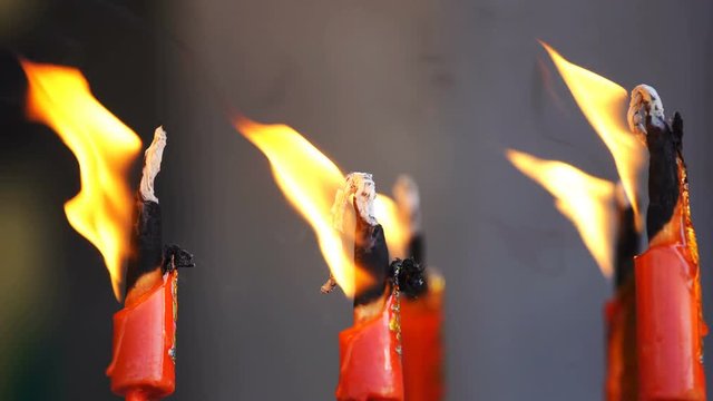 flame from burning red chinese candle in the temple