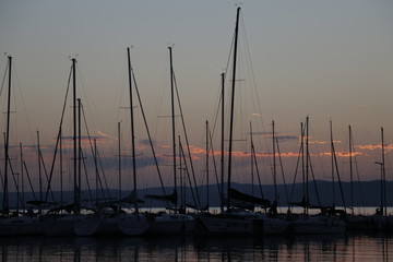 A warm, pleasant summer evening at Lake Balaton. Yachts, sailboats, boats with masts in the marina,...