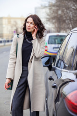 Obraz na płótnie Canvas fashion. beautiful woman in a bright coat talking on the mobile