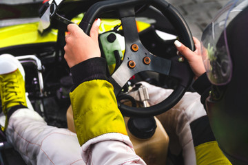 yellow Go-kart drivers shot from the back right at the start of the round leg on a gas