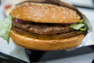 Close up of burger wrapped in foil paper on table