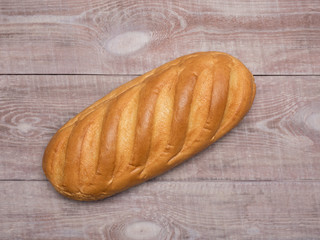 Loaf of bread on a light brown wooden background