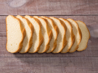 Nine pieces of white bread on a brown wooden background