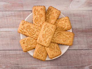 Cookies in saucer on wooden background