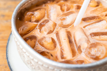close up of iced milk tea in stainless steel bowl