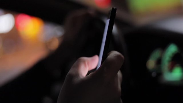 Texting with a smartphone in car at nigh