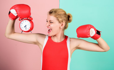 Girl athlete boxing gloves and alarm clock. Sport lifestyle and healthy regime. Habits and regime concept. Improve yourself. Overcome harmful habits. Time for training. Get used to personal regime