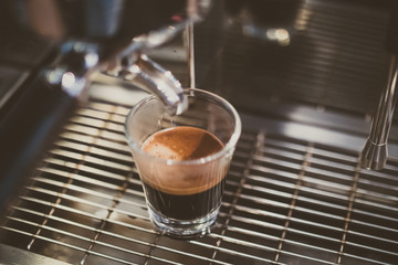 Close up of espresso pouring from coffee machine.