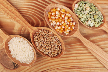 Seeds and grain in wooden spoons. Peas, rice, beans, wheat, corn