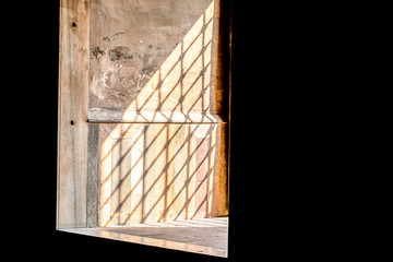 sun's rays fall into the window through the iron lattice