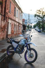 Fototapeta na wymiar Vertical photo. Vintage old retro off road enduro motorcycle at day time. Brutal urban lifestyle