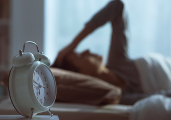 Woman waking up in the morning and alarm clock