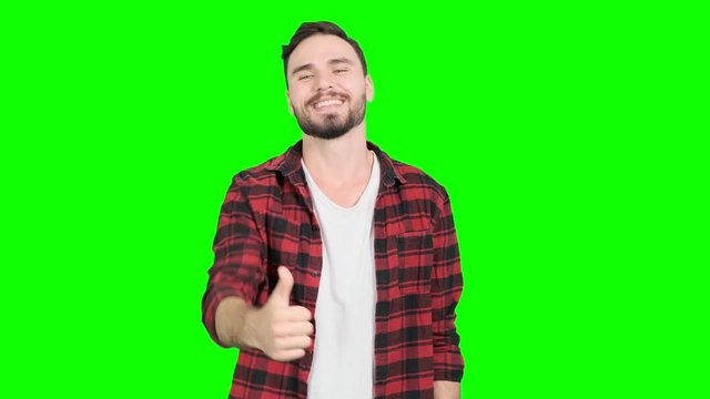 Young man showing his thumbs up on green screen, happy smile. White male. For Chroma key.
