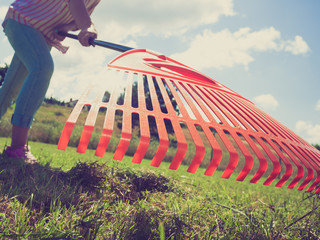 Unusual angle of woman raking leaves