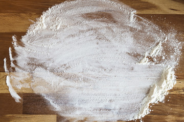 white flour on rustic wooden board.