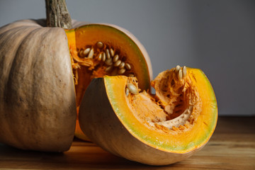 Ripe pumpkin cut on a wooden background