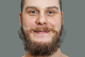 close-up face portrait of smiling happy bearded unshaven guy