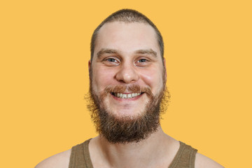 close-up face portrait of smiling happy bearded unshaven guy
