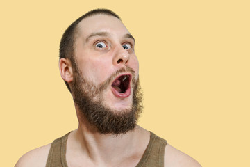 Very surprised scared funny face of a bearded guy with open mouth and big eyes on an isolated...