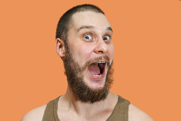 Very surprised scared funny face of a bearded guy with open mouth and big eyes on an isolated...