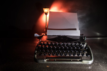 Old fashion typewritter on dark foggy background. Close up of vintage typewritter machine