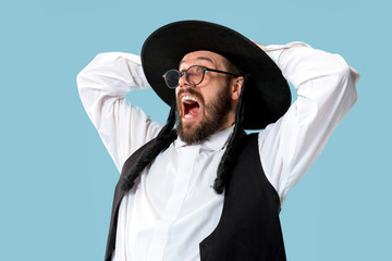 Portrait of a young orthodox Hasdim Jewish man at Jewish festival of Purim at studio. The purim, jewish, festival, holiday, celebration, judaism, pastry, tradition, cookie, religion concept.