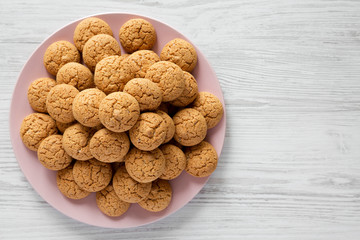 Almond cookies on pink plate over white wooden table, top view. Flat lay, overhead, from above. Space for text.