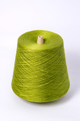 Green bobbin of yarn on a white background.Textile reel on isolated white background.