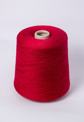Red bobbin of yarn on a white background.Textile reel on isolated white background.