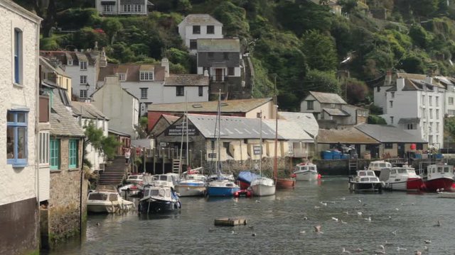 Small boat comes in to moor at Polperro harbour on a sunny Summer day, Cornwall, England