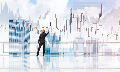 Sunrise above skyscrapers and engineer in helmet drawing globalization concept