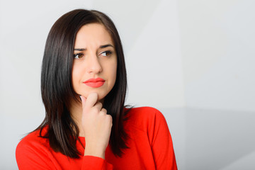 brunette thoughtful young worried woman wearing red