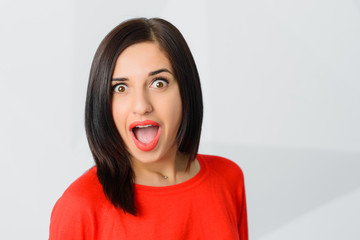 brunette surprised astonished cheerful young woman wearing red
