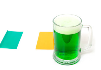 One big glass of green beer on the background of the flag of Ireland. St Patrick's Day holiday poster concept.