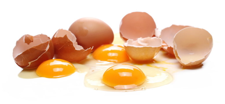 Broken eggs, eggshells with yolk isolated on white background