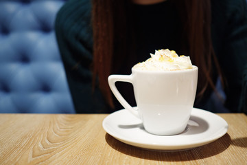girl with a spoon tries foam with cappuccino.