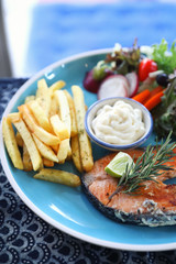 Roasted salmon steak , baked salmon with salad fresh vegetable pm wooden table