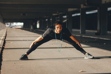 Fototapeta na wymiar Young sports man stretching outdoors