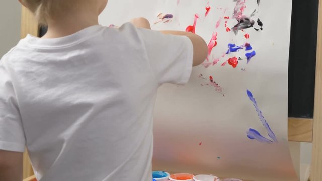 Cute little boy (toddler, two years old) is painting. Washable finger paints for Babies Kids. Art, creative, early childhood education to children concept, kindergarten, pre-primary, nursery school.