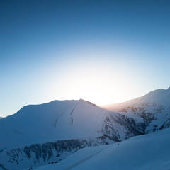Snow mountains against the sun. Winter background